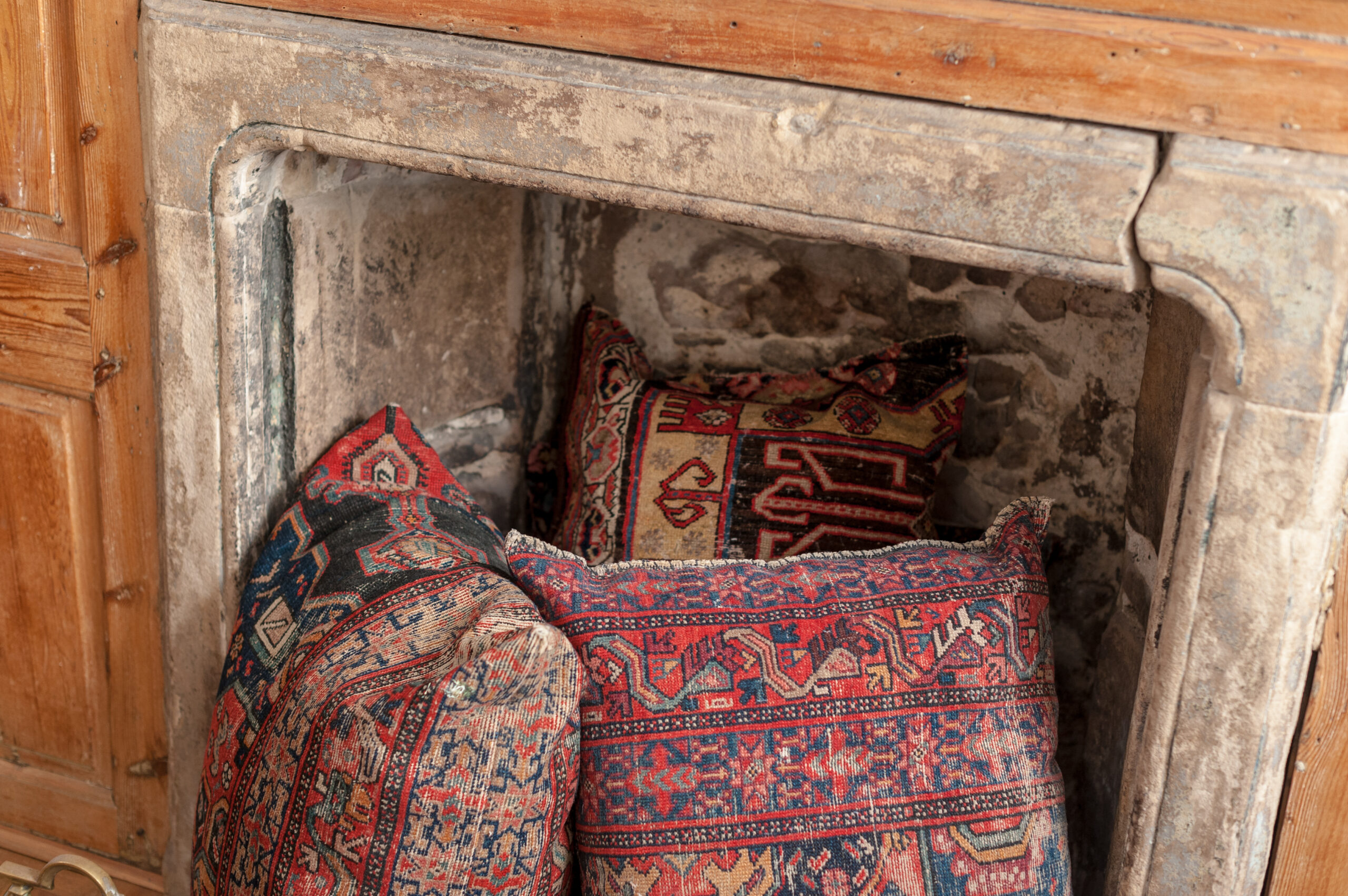 A fireplace with cushions inside featured at The Whole Works Complementary Therapy and Counselling Centre Building